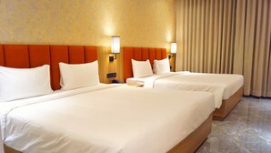 A hotel room with two beds, a wooden headboard, a telephone, and a wall-mounted lamp. - Econostay (Bhilwara)