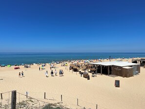 A beach with a wooden structure labeled 'COLLEUR LOCALE' and a fenced area.