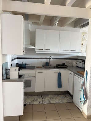 A modern kitchen with white cabinets, a built-in oven, a sink, and a dishwasher.