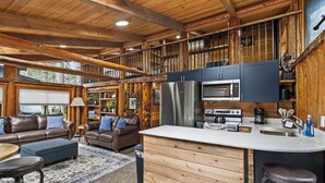 A cabin interior with a kitchen, living area, and a balcony. - Unique Log cabin @ Rainier with Hot Tub-Fast WiFi (Ashford)