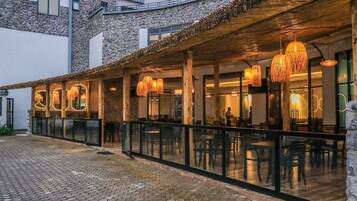 Un restaurant doté d’une terrasse, de murs en pierre et de guirlandes lumineuses.