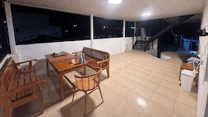 Ein geräumiger Balkon mit Holztisch, Stühlen und einem Schachbrett.
