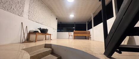 A staircase leading to a room with a wooden bench, a small table, and a wall with a textured pattern.