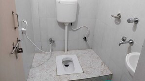 A small, tiled bathroom with a toilet, bidet, and sink.