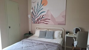 A bedroom with a bed, bedside table, chair, and a wall-mounted mirror. - Cyberjaya Tamarind Suites, Mediya Homestay (Cyberjaya)