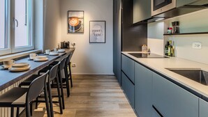 A modern kitchen with a long countertop, built-in microwave, and a coffee machine. - Family and Friends by Interhome (Riva del Garda)