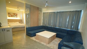 A modern living room with a sectional sofa, a coffee table, and a blue armchair.