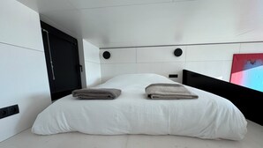 A modern bedroom with a large bed, a black headboard, and a white wall. - Brand new: Eco-logement Koda Loft 2 - Introductory price! (Hommert)