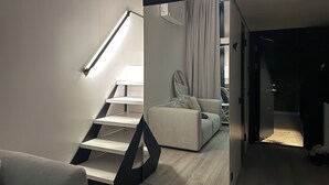 A modern interior with a staircase, a sofa, and a view into another room. - Brand new: Eco-logement Koda Loft 2 - Introductory price! (Hommert)