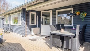 Een overdekt terras met tuinmeubilair, een boiler en een schoorsteen.
