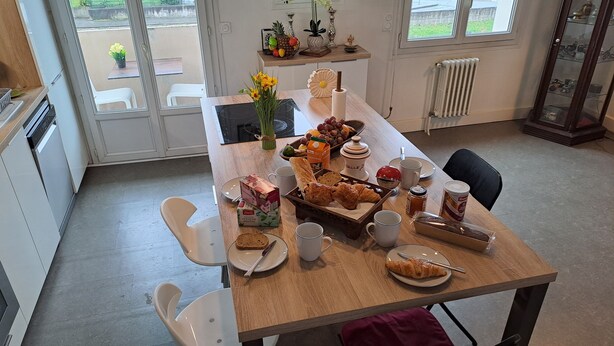 Et spisebord med mad, drikke og en blomstervase.