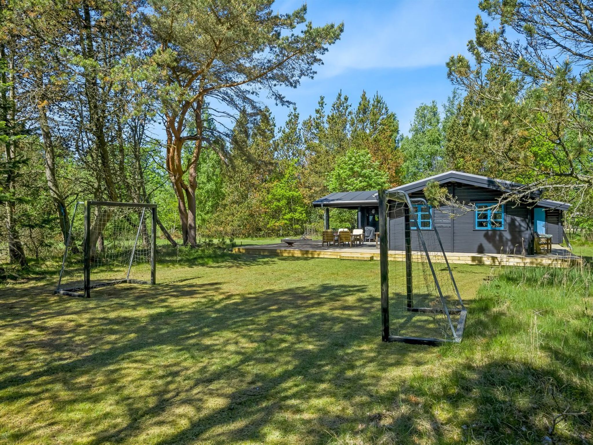 Une maison avec un patio, une balançoire et une cour clôturée.
