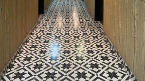 A hallway with patterned flooring, wooden paneling on the walls, and doors leading to rooms. - The Palace Inn hotel with in peaceful Lahore (Lahore)