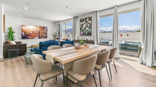 A modern living room with a dining area, large windows, and a view of the outdoors. - 9 Bedroom/Lazy River/Sleeps 24/Pickleball/Theater (Coachella)