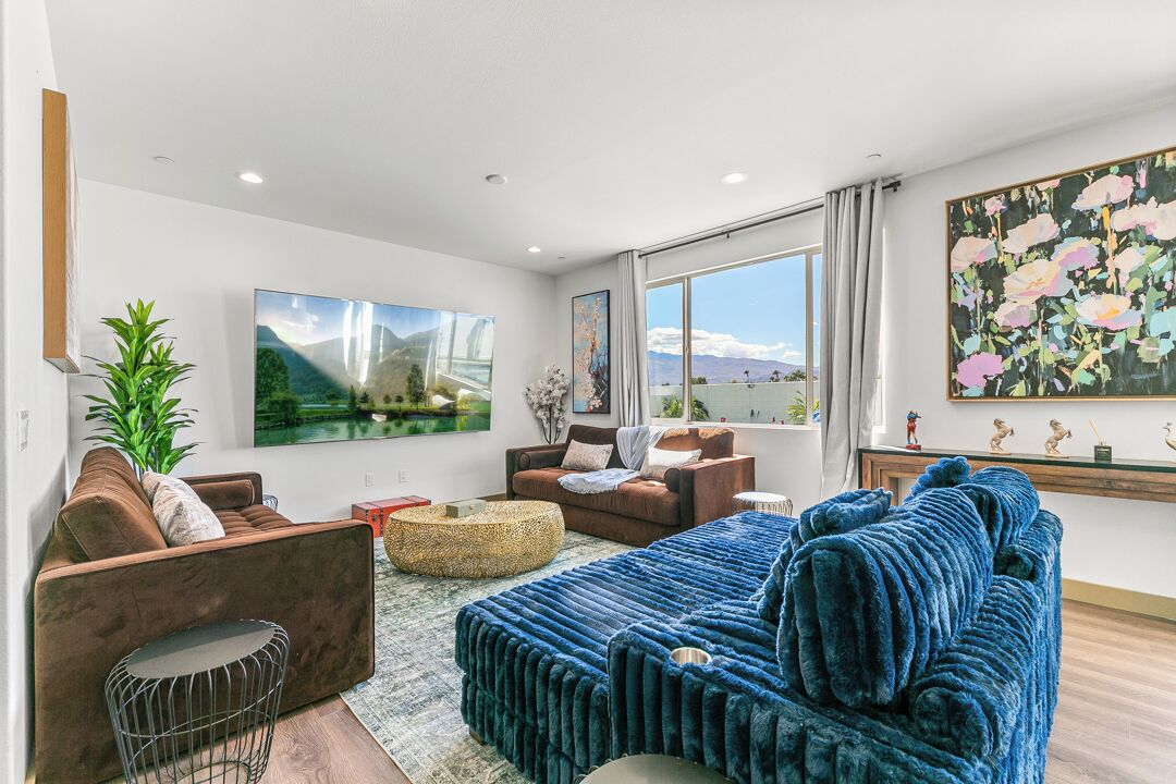 A modern living room with a sofa, armchairs, a coffee table, and artwork on the walls.