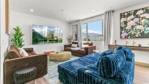A modern living room with a sofa, armchairs, a coffee table, and artwork on the walls. - 9 Bedroom/Lazy River/Sleeps 24/Pickleball/Theater (Coachella)