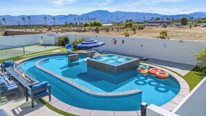 A swimming pool with a hot tub, lounge chairs, and a view of mountains. - 9 Bedroom/Lazy River/Sleeps 24/Pickleball/Theater (Coachella)
