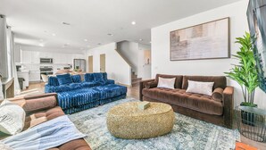 A modern living room with a sofa set, a coffee table, and a large painting on the wall. - 9 Bedroom/Lazy River/Sleeps 24/Pickleball/Theater (Coachella)