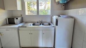 Uma cozinha compacta com micro-ondas, pia e geladeira.