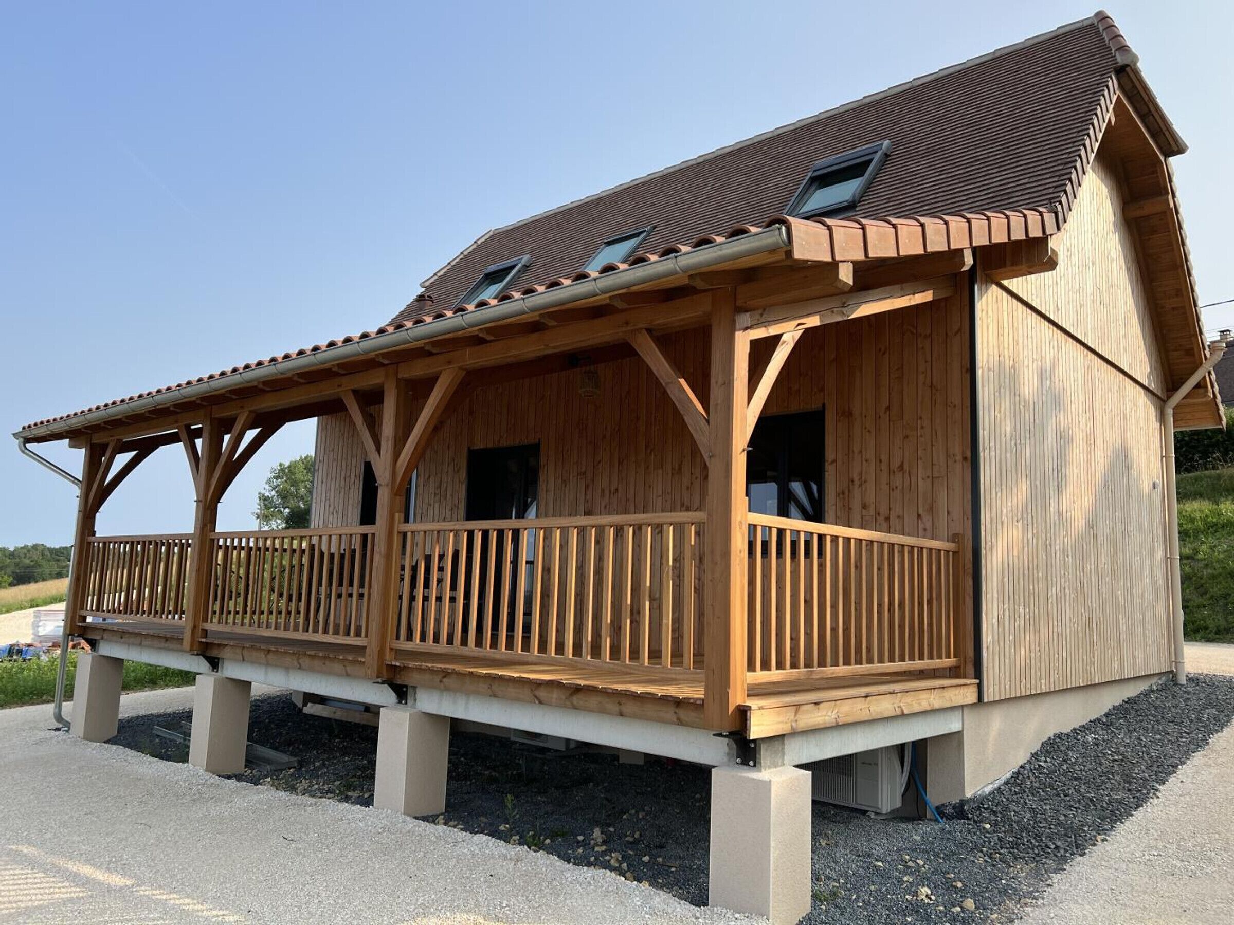 Un bâtiment en bois doté d’un balcon, d’un toit en pente et d’une fenêtre.
