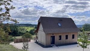A wooden barn with a sloped roof, a small porch, and a gravel driveway. - Single-storey house, pets allowed - 2 guests (Preyssac-d'Excideuil)