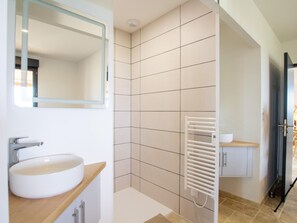 A modern bathroom with a white sink, a mirror, a towel rack, and a shower area. - Single-storey house, pets allowed - 2 guests (Preyssac-d'Excideuil)