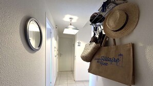 En hall med en spegel, en upphängd hatt och en väska med texten ”Saint Hilaire de Riez”.
