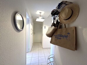 Ein Flur mit Spiegel, Hut und Tasche mit Aufschrift 'Saint Hilaire de Riez'.