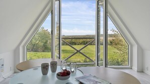 A room with a glass table, two cups, a bowl of strawberries, and a magazine. - "Sigbritt" - 3.7km from the sea by Interhome (Nexø)