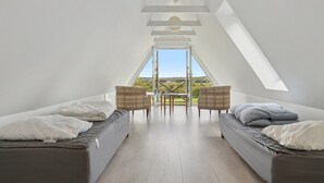 A high-ceilinged room with two beds, a dining table, and chairs, and a large skylight. - "Sigbritt" - 3.7km from the sea by Interhome (Nexø)