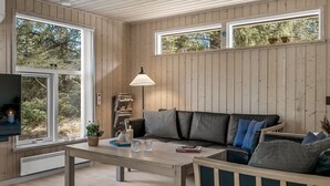 Ein Zimmer mit Holzvertäfelung, einer Couch, einem Tisch und einer Lampe.