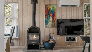 Ein modernes Wohnzimmer mit Kaminofen, einem großen abstrakten Gemälde und einem Flachbildfernseher.