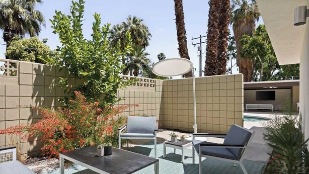 A patio area with outdoor furniture, a pool, and a view of palm trees. - Hugh Kaptur Hideaway Villa (Palm Desert)
