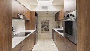 A modern kitchen with wooden cabinets, stainless steel appliances, and a skylight. - Hugh Kaptur Hideaway Villa (Palm Desert)
