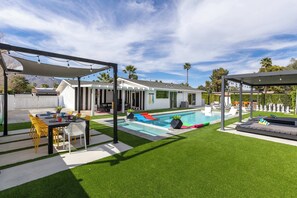 A backyard with a swimming pool, a covered patio, and a lawn. - Private Palm Springs Oasis With Saltwater Pool Spa (Palm Springs)