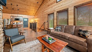 Een houten chalet van binnen met een keuken, eethoek en woonkamer.