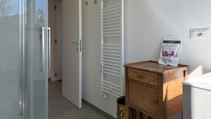 A room with a sliding glass door, a white radiator, a wooden cabinet, and a Welcome Kit on the wall. - The Clover Close to Citylife Metro and Fiera (Milan)