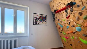 A room with a bed, a climbing wall, a window, and a radiator. - The Clover Close to Citylife Metro and Fiera (Milan)