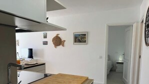 Una cucina moderna con un tavolo in legno, un forno a incasso e una scultura a muro raffigurante un pesce.