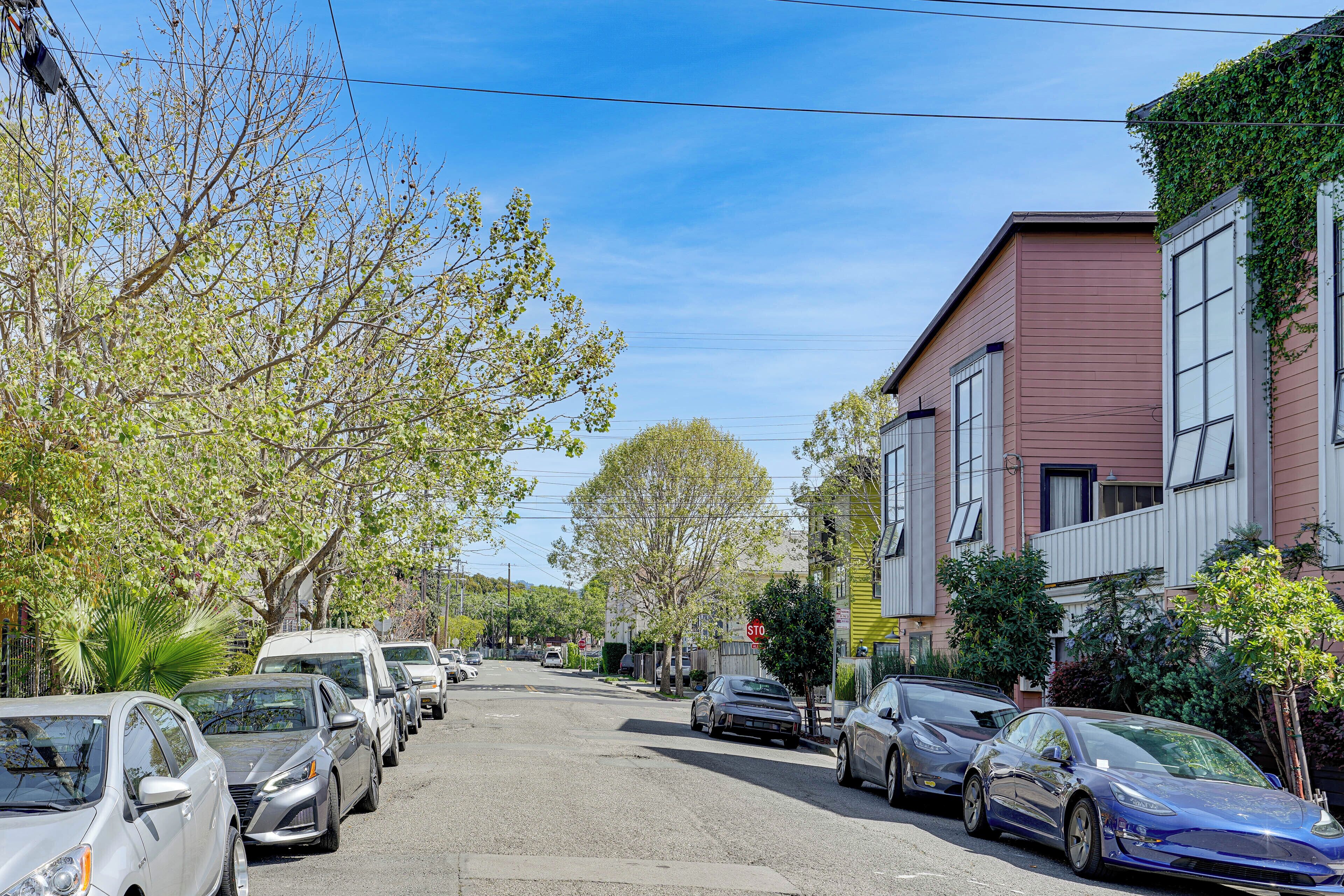A street lined with parked cars and houses.