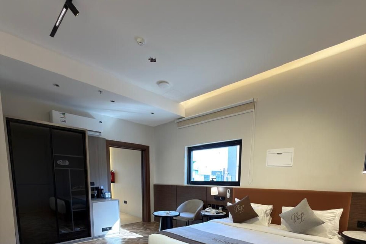 Una habitación de hotel con una cama grande, un escritorio, una silla y un televisor.