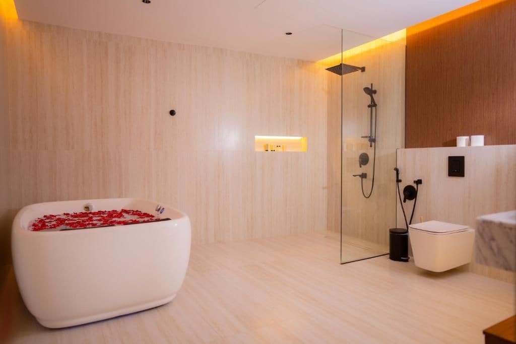 A modern bathroom with a freestanding bathtub, a glass-enclosed shower, and a marble-topped sink.