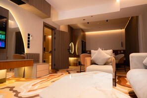 A modern hotel room with a flat-screen TV, a desk, a sofa, and a patterned carpet. - RICH LOBBY HOTEL HAIL (Ha'il)