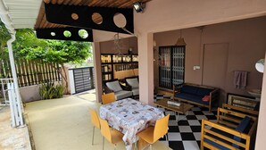 A covered outdoor seating area with a checkered floor, a table with a patterned tablecloth, and a sofa. - Private 3BR Villa & Pool | Flic en Flac | 100% Privacy & 7Mins walk to the beach (Flic en Flac)