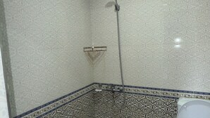 A bathroom with a shower, toilet, and sink, all with patterned tiles.