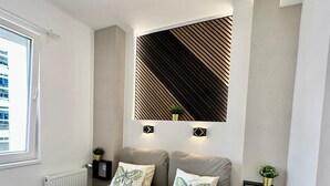 Una camera da letto moderna con un letto, due comodini, una lampada a parete e una finestra.