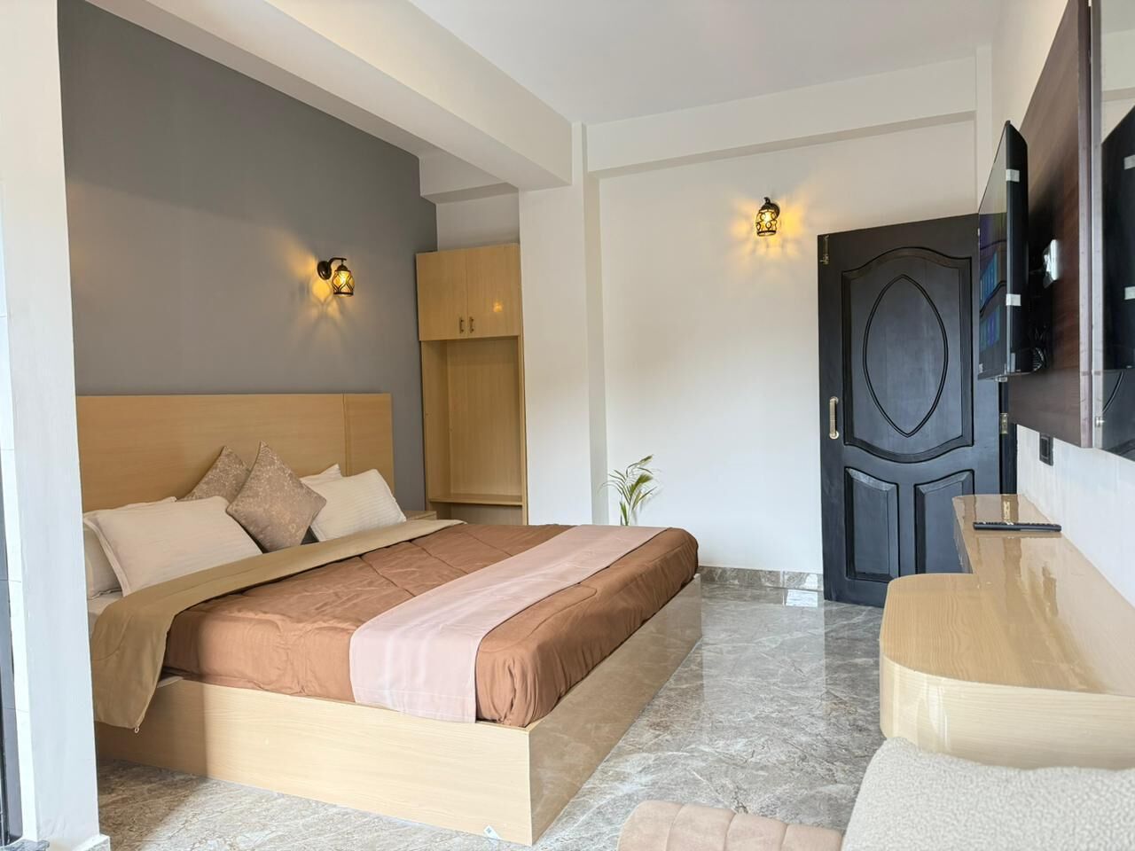 A modern bedroom with a bed, bedside tables, a wardrobe, and a TV.