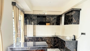 Una cucina moderna con un piano di lavoro in marmo nero, un piano cottura integrato e un lavello.