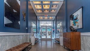 A hotel lobby with a marble bench, a wooden dresser, and a large abstract painting. - Landing Furnished Apartments near YSM (New Haven)