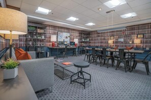Une bibliothèque moderne dotée d’étagères, d’un poste informatique et d’espaces aménagés pour s’asseoir.